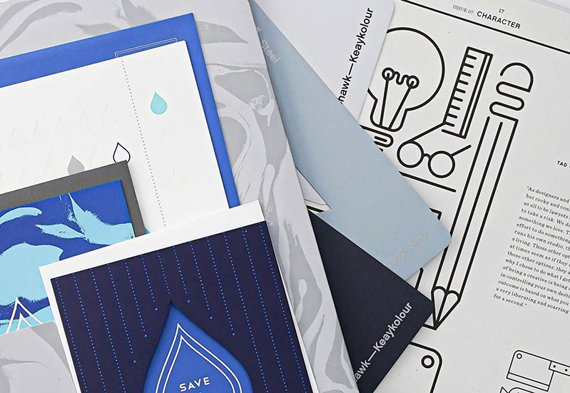 Stack of updated brochures, fliers, and folders professionally printed for a nonprofit event display